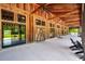 Expansive outdoor porch featuring wooden beams, large windows, and sleek ceiling fans, offering a serene retreat with nature views at 1510 Old Rosebud Trl, Awendaw, SC 29429