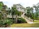 Front exterior of the house showcasing the yard and palm trees at 1510 Old Rosebud Trl, Awendaw, SC 29429