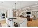Open-concept kitchen with a center island, stainless steel appliances, and views into the living area at 1510 Old Rosebud Trl, Awendaw, SC 29429