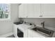 Spacious laundry room with modern washer, dryer, sink and ample cabinet space at 1510 Old Rosebud Trl, Awendaw, SC 29429