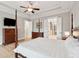 A spacious main bedroom with hardwood floors, tray ceiling, ensuite access, and a wall-mounted television at 1510 Old Rosebud Trl, Awendaw, SC 29429