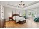 Spacious primary bedroom with tray ceiling, large windows, and hardwood floors at 1510 Old Rosebud Trl, Awendaw, SC 29429