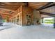Spacious outdoor venue with wooden beams, an exposed ceiling, and a brick fireplace, all with a view of a tranquil lake at 1510 Old Rosebud Trl, Awendaw, SC 29429