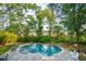 Relaxing in-ground pool with clear blue water and stone patio, surrounded by mature trees for privacy at 1510 Old Rosebud Trl, Awendaw, SC 29429