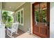 Cozy porch with rocking chairs and a wood door at 1510 Old Rosebud Trl, Awendaw, SC 29429
