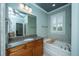 Bathroom with granite countertops, wood cabinetry, and a separate soaking tub by a shuttered window at 1512 Eagle Landing Blvd, Hanahan, SC 29410