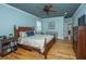 Bright bedroom with hardwood floors, a wood-frame bed, and lots of natural light from shuttered windows at 1512 Eagle Landing Blvd, Hanahan, SC 29410