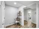 Hallway leading to a bathroom, featuring a desk nook with a white chair and wood floors at 153 High Hammock Villas, Seabrook Island, SC 29455