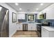 Well-lit kitchen featuring modern appliances, white cabinets, blue tile backsplash, and a stainless steel sink at 153 High Hammock Villas, Seabrook Island, SC 29455