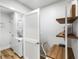 A laundry room and office nook featuring a stackable washer/dryer and floating wood shelves at 153 High Hammock Villas, Seabrook Island, SC 29455