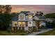 Stunning home at dusk, featuring a charming front porch, beautiful landscaping, and warm lighting, creating an inviting atmosphere at 1537 Tomato Farm Cir, Mount Pleasant, SC 29464