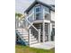 Rear exterior of a two-story home with stairs to an outdoor deck, grill, and meticulously landscaped yard at 1537 Tomato Farm Cir, Mount Pleasant, SC 29464