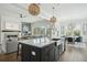 Open-concept kitchen featuring an island, stainless steel sink, and a view of the living and dining areas at 1537 Tomato Farm Cir, Mount Pleasant, SC 29464
