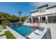Inviting backyard pool featuring lounge chairs, elegant patio, waterfall feature and partial home exterior at 1537 Tomato Farm Cir, Mount Pleasant, SC 29464