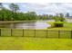 Beautiful backyard with lush green grass, a black iron fence, and a scenic pond at 1740 Agate Bay Dr, Mount Pleasant, SC 29466