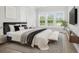 Stylish main bedroom with plush bedding, large windows, and views of the outdoor landscape at 1740 Agate Bay Dr, Mount Pleasant, SC 29466