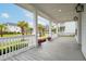 Inviting front porch with white railing, grey wood flooring, and neighborhood views framed by palm trees at 1740 Agate Bay Dr, Mount Pleasant, SC 29466