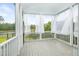 Enclosed porch with white railings and curtains, offering a view of the nearby pond at 1740 Agate Bay Dr, Mount Pleasant, SC 29466