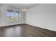 Empty dining room with wood flooring, a chandelier, and large windows overlooking the front yard at 199 Belfort Pl, Summerville, SC 29486