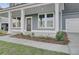 Close-up of a covered front porch with white columns, a dark front door, and manicured landscaping at 199 Belfort Pl, Summerville, SC 29486