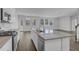 Kitchen features an island, stainless appliances, white cabinetry, and wood flooring that opens to a living area at 199 Belfort Pl, Summerville, SC 29486