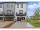 Modern townhomes with garages and balconies, featuring gray and white siding, and ample parking space at 207 Somerset Acres Dr, Summerville, SC 29486