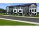 Charming row of townhomes featuring a modern black and white color scheme and well-manicured lawns at 207 Somerset Acres Dr, Summerville, SC 29486