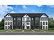 Beautiful row of townhomes with a modern black and white design, set against a blue sky at 207 Somerset Acres Dr, Summerville, SC 29486