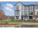 Stylish townhomes with a modern black and white design, enhanced by lush landscaping and a sidewalk at 207 Somerset Acres Dr, Summerville, SC 29486