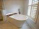 Bright bathroom features a free-standing tub with natural light shining through the window at 2128 Breezy Point Dr, Mount Pleasant, SC 29466