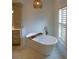 This bathroom features a free-standing tub with a bronze faucet and shutters on the window at 2128 Breezy Point Dr, Mount Pleasant, SC 29466