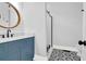 Modern bathroom with a blue vanity, a round mirror, a shower, and stylish tile floors at 2128 Breezy Point Dr, Mount Pleasant, SC 29466