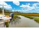A boat's motor is attached to a dock on a marshy shore, ready for adventure and relaxation at 2128 Breezy Point Dr, Mount Pleasant, SC 29466