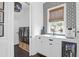 Stylish laundry room featuring modern appliances, white cabinets, and a window with patterned wallpaper at 2128 Breezy Point Dr, Mount Pleasant, SC 29466