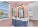 Bathroom featuring a navy blue vanity, decorative mirror, and a pink wall at 221 Trillium Ave, Summerville, SC 29483