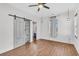 Bedroom featuring wood floors, a ceiling fan, and gray barn doors over a storage unit at 221 Trillium Ave, Summerville, SC 29483