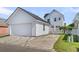 View of the detached garage with a driveway, complementing the main house with matching white siding at 221 Trillium Ave, Summerville, SC 29483