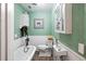 A small, stylish bathroom with green walls, a clawfoot tub, and modern fixtures at 225 Baxter Ln, Walterboro, SC 29488
