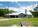 Charming gray home with a metal roof, covered patio, and a lush green lawn and garden at 225 Baxter Ln, Walterboro, SC 29488