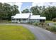 Charming single-story home with a manicured front lawn, and a view of a red barn in the background at 225 Baxter Ln, Walterboro, SC 29488