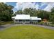 A charming exterior view of a single-story home featuring a welcoming front porch and a red barn at 225 Baxter Ln, Walterboro, SC 29488