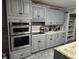 Updated kitchen features shaker style cabinets, stainless appliances, granite counters, tile backsplash, and tile flooring at 225 Baxter Ln, Walterboro, SC 29488