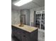 Kitchen with gray cabinetry, stone-look backsplash, stainless refrigerator, island with granite countertop, and gray tile floors at 225 Baxter Ln, Walterboro, SC 29488