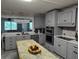 Renovated kitchen with stainless appliances, gray shaker cabinets, white countertops, and a center island at 225 Baxter Ln, Walterboro, SC 29488
