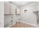 Laundry room with cabinets, patterned floor, and octagonal window at 225 Baxter Ln, Walterboro, SC 29488
