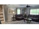 Spacious living room with plush brown leather seating, ceiling fan, neutral walls, and patterned area rug at 225 Baxter Ln, Walterboro, SC 29488