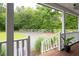 View from the front porch towards the long driveway with a white fence, plants, and trees at 225 Baxter Ln, Walterboro, SC 29488