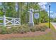 Community entrance sign displaying the neighborhood name with flowers, trees, and a white fence at 260 Sweet Cherry Ln, Summerville, SC 29486