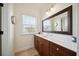 Bathroom with wood cabinets and white countertop vanity offering window view and a large framed mirror at 3011 River Vista Way, Mount Pleasant, SC 29466