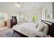 Bedroom with white walls and white duvet cover on bed with view of bathroom and outdoor deck or patio at 3011 River Vista Way, Mount Pleasant, SC 29466